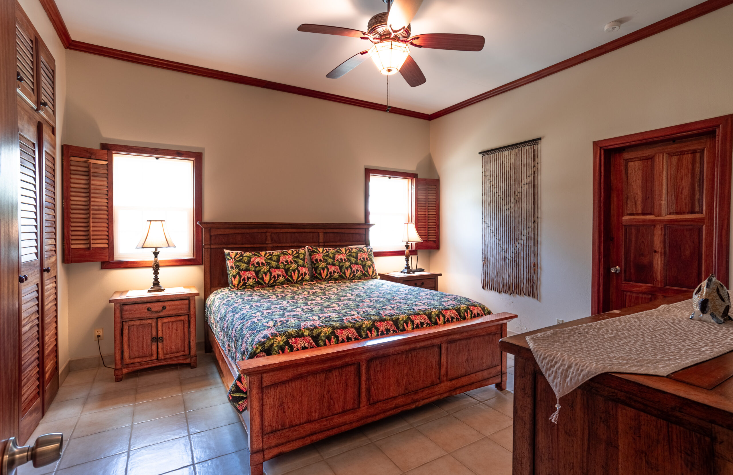 Cozy bedroom with queen bed, perfect for accommodating children or additional guests, adorned with tropical touches.