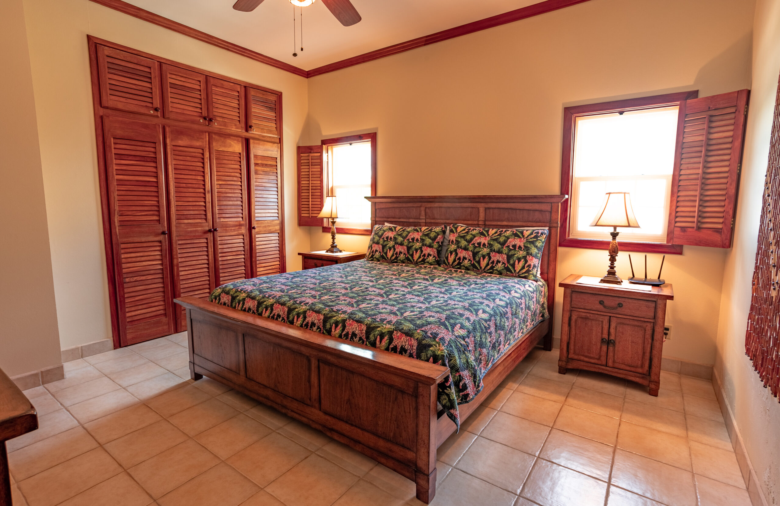 Cozy bedroom with queen bed, perfect for accommodating children or additional guests, adorned with tropical touches.