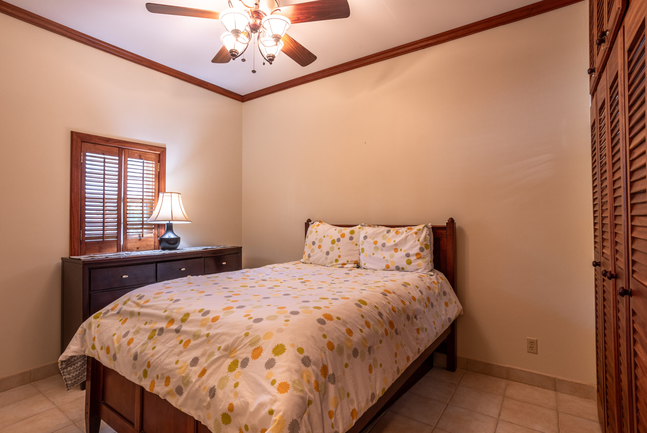 Warm and inviting master bedroom with a comfortable king-size bed, tropical accents, and a cozy atmosphere